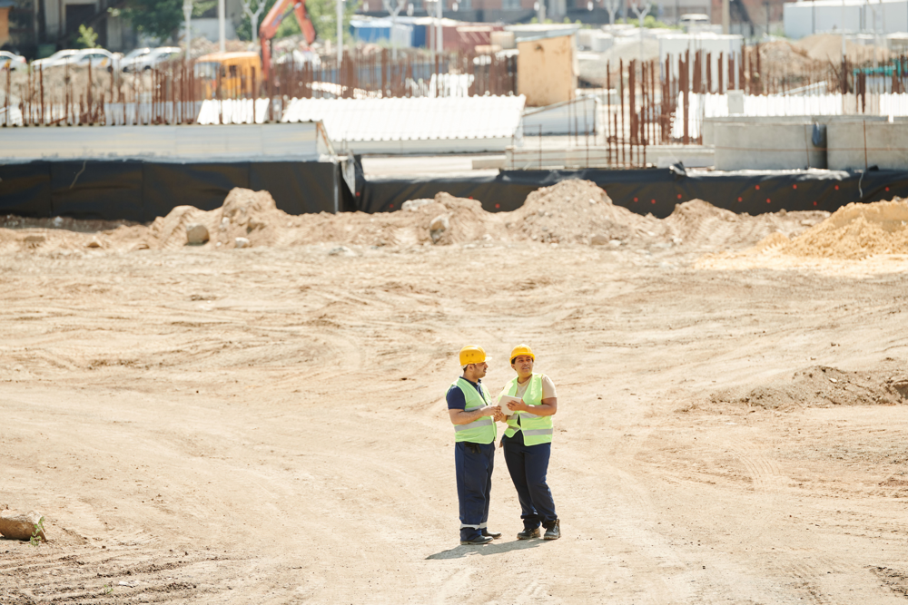 Construction workers discussing plans on site